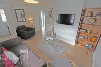 Large Lounge with large LED Smart wall mounted TV, Sofa & Chair, recliner and other lounge furniture. A welcoming homely space for relaxing and socialising